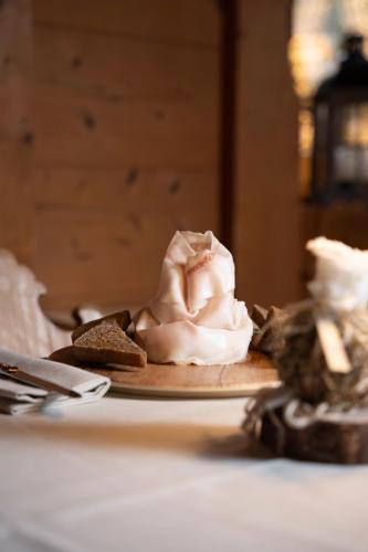 a plate with whipped cream and a piece of bread at Hotel Edelhof in Tarvisio