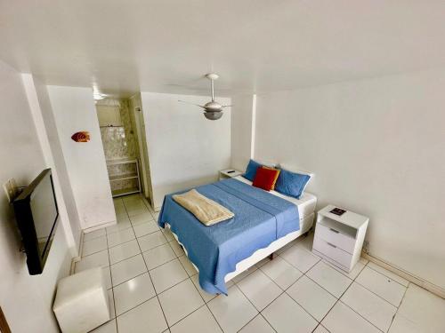 ein Schlafzimmer mit einem Bett und einem Fernseher in der Unterkunft Duplex de Frente para a Praia - Angra Inn in Angra dos Reis