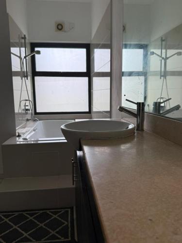 a bathroom with a sink and a bath tub at Le Meritt Appartments in Quatre Bornes