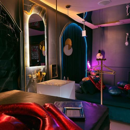 a room with a bed and a sink and a mirror at Love Room 85 avec Jacuzzi & Terrasse Privé in Kortrijk