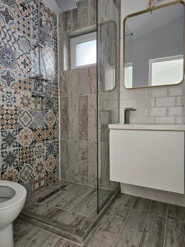 un bagno con un water, un lavandino e uno specchio di FurtuNest 