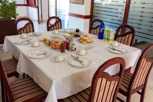 a table with a white table cloth and food on it at Vila Lux Milikic in Kraljevo