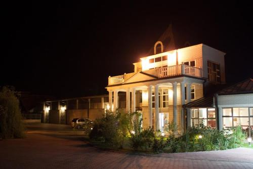 a large building with lights on it at night at Vila Lux Milikic in Kraljevo