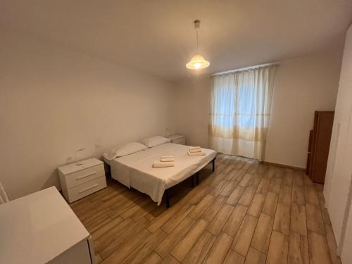 een slaapkamer met een bed en een houten vloer bij Enjoy The Silence Flat in Orosei