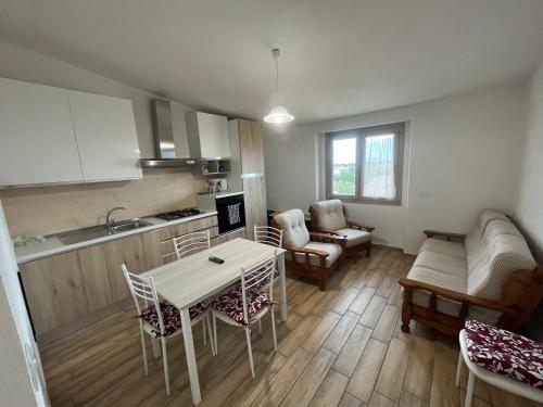 een keuken en woonkamer met een tafel en stoelen bij Enjoy The Silence Flat in Orosei