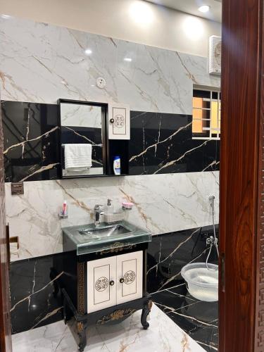 een zwart-witte badkamer met een wastafel en een spiegel bij Rana Villa's & Rest Stop in Lahore