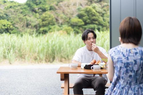 a woman sitting at a table talking to a man at A-Mami 315 in Amami