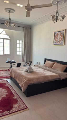 a bedroom with a large bed and a red rug at Qantab village room in Muscat