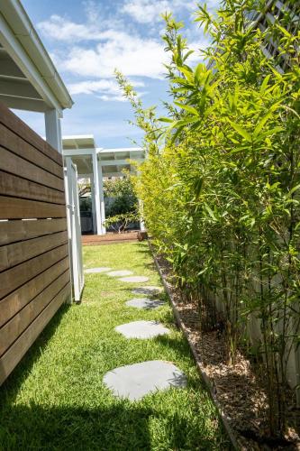 a garden with stepping stones next to a house at Studio11 - Vincentia in Vincentia
