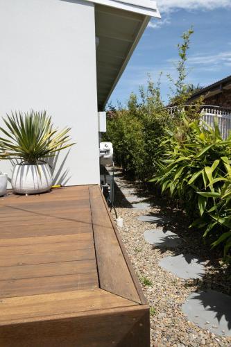 a wooden deck with plants on the side of a house at Studio11 - Vincentia in Vincentia