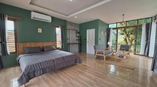 una camera da letto con pareti verdi, un letto e una sedia di Mama Home Misty Lakeside a Pong