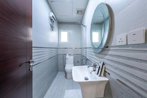 a bathroom with a sink and a mirror and a toilet at Sea View Villa فيلا إطلالة بحرية in Jeddah