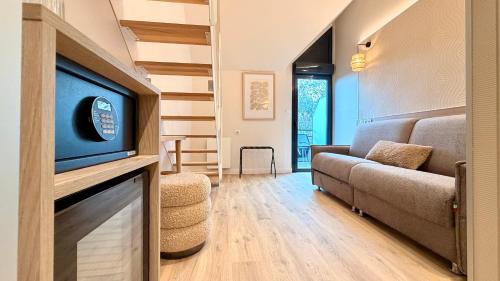 a living room with a couch and a tv at La Cremaillere Hôtel-Restaurant in Courseulles-sur-Mer