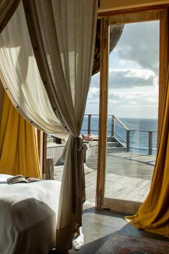 a bedroom with a bed and a view of the ocean at Monarch Beach Villa in Cimbene