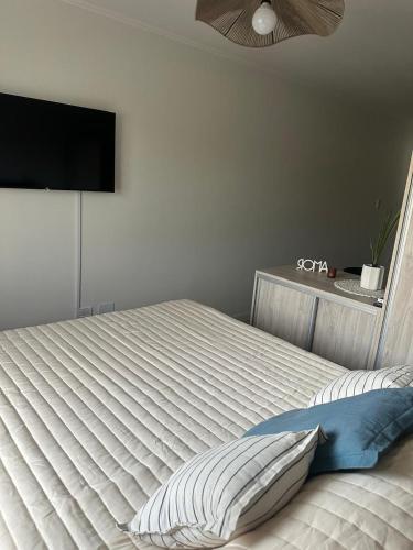una camera da letto con un letto bianco con una TV a schermo piatto di Recreo a Necochea