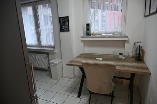 een kleine keuken met een houten tafel en een stoel bij ROTH Apartments Wuppertal-HBF in Wuppertal