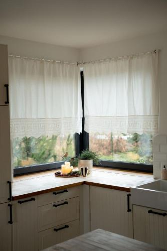 a kitchen with white cabinets and a window and a counter at Willa Aleksandria in Konopiska