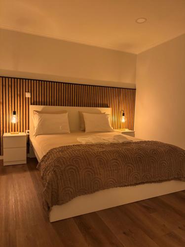 a bedroom with a large bed with two lamps on it at Casa Carvalho in Peso da Régua