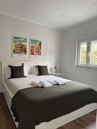 比索达雷加Casa Carvalho的一间白色的卧室，有一张大床，配有两个枕头