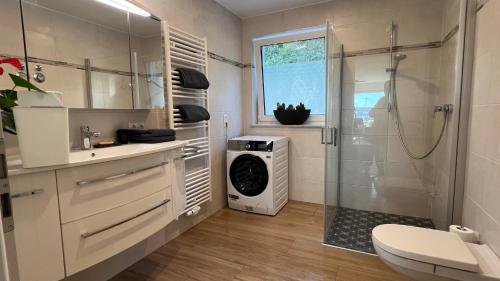a bathroom with a shower and a washing machine at FeWo-Brombachseeblick in Absberg