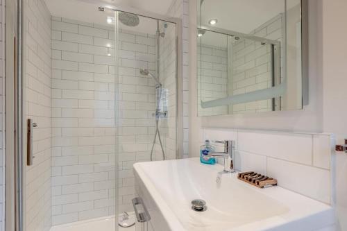 a white bathroom with a sink and a shower at 3 Bed in Croyde oc-t30753 in Croyde