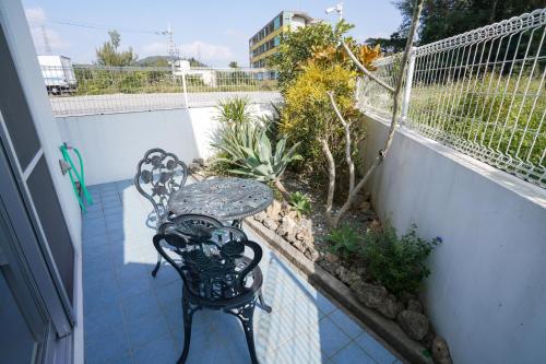 a patio with a table and a bench on a balcony at Villa Sunbeams ヴィラ・サンビームス in Kin