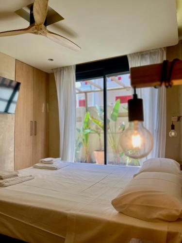 a bedroom with a large white bed with a window at Apartamentos Flores playa in La Mata