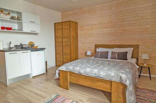 ein Schlafzimmer mit einem Bett mit einer Holzwand in der Unterkunft Apartments Mont Jahorina in Jahorina