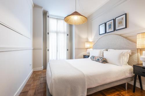 a bedroom with a white bed and a window at Madalena Hermitage in Lisbon