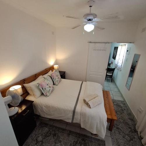 a bedroom with a bed and a ceiling fan at Albert's Nest in Kimberley