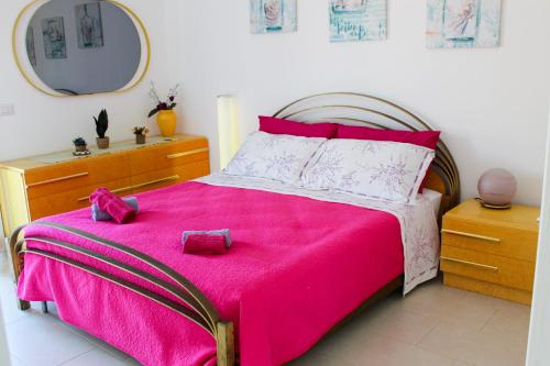 een slaapkamer met een bed met een roze deken bij A Casuzza di Pina e Raffaele in Villaggio Azzurro