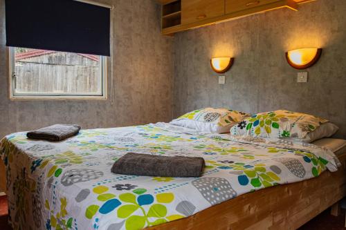 a bedroom with a large bed with colorful sheets and pillows at La Belle Vue in Durmignat