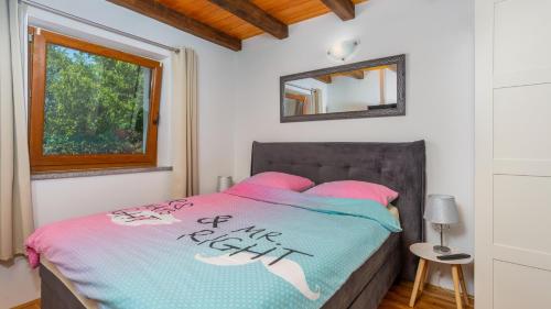 een slaapkamer met een bed met roze kussens en een spiegel bij Vila Gostinjac 2 with pool Krk by Villas Guide in Gostinjac