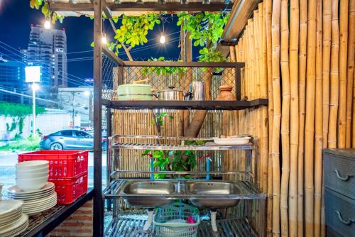 een keuken met een gootsteen en servies aan de muur bij Camping&Cafe Khao Phratamnak in Pattaya South