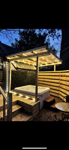 a wooden pergola with a bed and a table at Danu 1A -Hot Tub-Perth-Pet Friendly-Luxury-Romantic in Perth