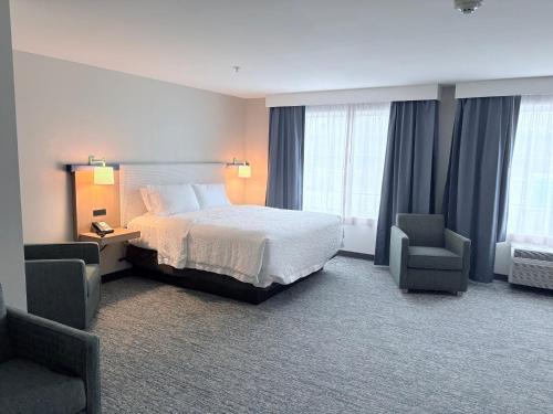 a hotel room with a bed and two chairs at Garner Hotel Mahwah by IHG in Mahwah