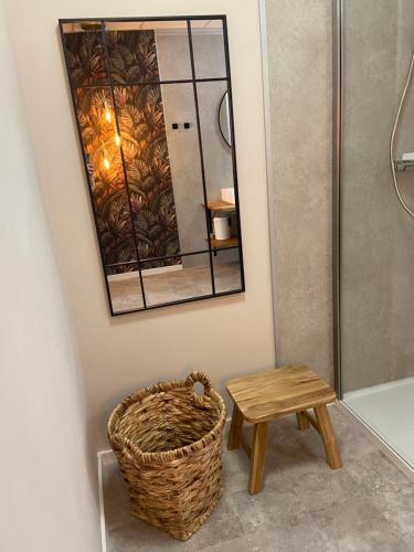 ein Badezimmer mit Spiegel, Korb und Hocker in der Unterkunft Lagerhaus Gabriel-Oasen in der Stadt in Zweibrücken