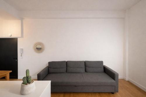 ein Wohnzimmer mit einem Sofa und einem Kaktus in der Unterkunft Studio Moderne, Le Carré Dor, À 3min Plage, NICE CENTRE in Nizza