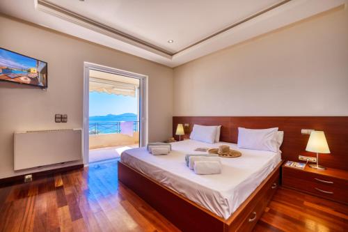 um quarto com uma cama grande e uma janela grande em Villa Aeolos em Barbati