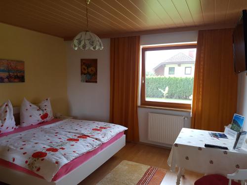 Schlafzimmer mit einem Bett, einem Fenster und einem Tisch in der Unterkunft Haus zur Sonne in Sankt Urban