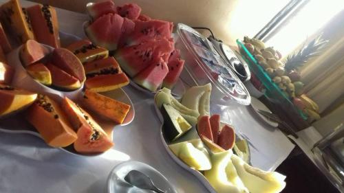 Porto Marlin Hotel في كونسيساو دا بارا: طاولة مليئة بأطباق الطعام مع الفاكهة
