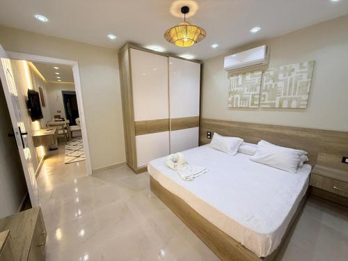 ein Schlafzimmer mit einem großen weißen Bett in einem Zimmer in der Unterkunft Nubia El Karma Beach Resort & Aqua Park in Hurghada