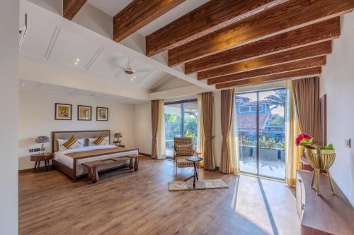 a bedroom with a bed and a large window at Valley View 5-BHK Villa With Private Pool, Sit-out Areas, TT Table, Pool Table , Bar & Scenic Views in Mapusa