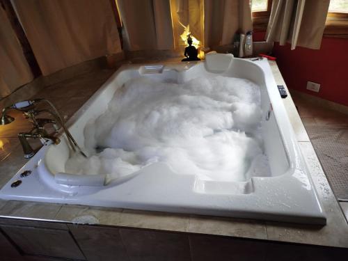 eine mit Schaum gefüllte Badewanne in einem Badezimmer in der Unterkunft Lejana Casa de montaña in Lago Puelo