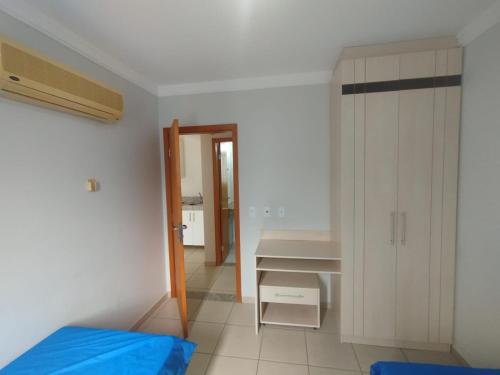 Schlafzimmer mit einem Bett, einem Waschbecken und einem Schreibtisch in der Unterkunft Apart Flat Aguas da Serra in Rio Quente