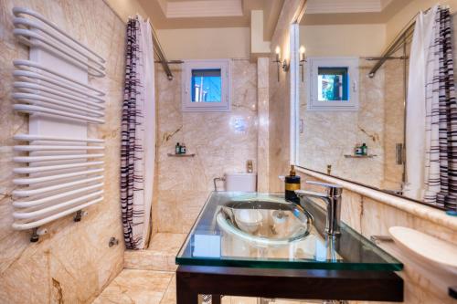 um banheiro com pia e espelho em Villa Aeolos em Barbati