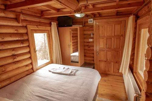 a bedroom with a bed in a log cabin at OBA KÜTÜK EVLERi in Seben