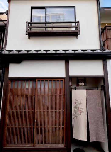 a building with a gate and a bench on top at Kamozen Kyoto Machiya Stay in Kyoto