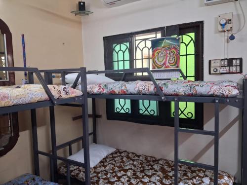 a room with three bunk beds and a window at MSVNATIVE HOME Stay Near Airport in Chennai
