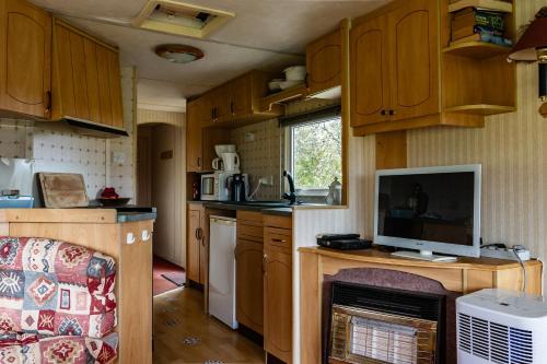 eine kleine Küche mit Holzschränken und einem Kamin in der Unterkunft La Belle Vue in Durmignat